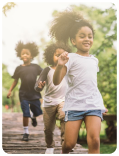 A group of children running on the sidewalk.