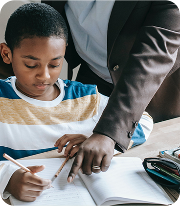 A man helping a boy with his homework.